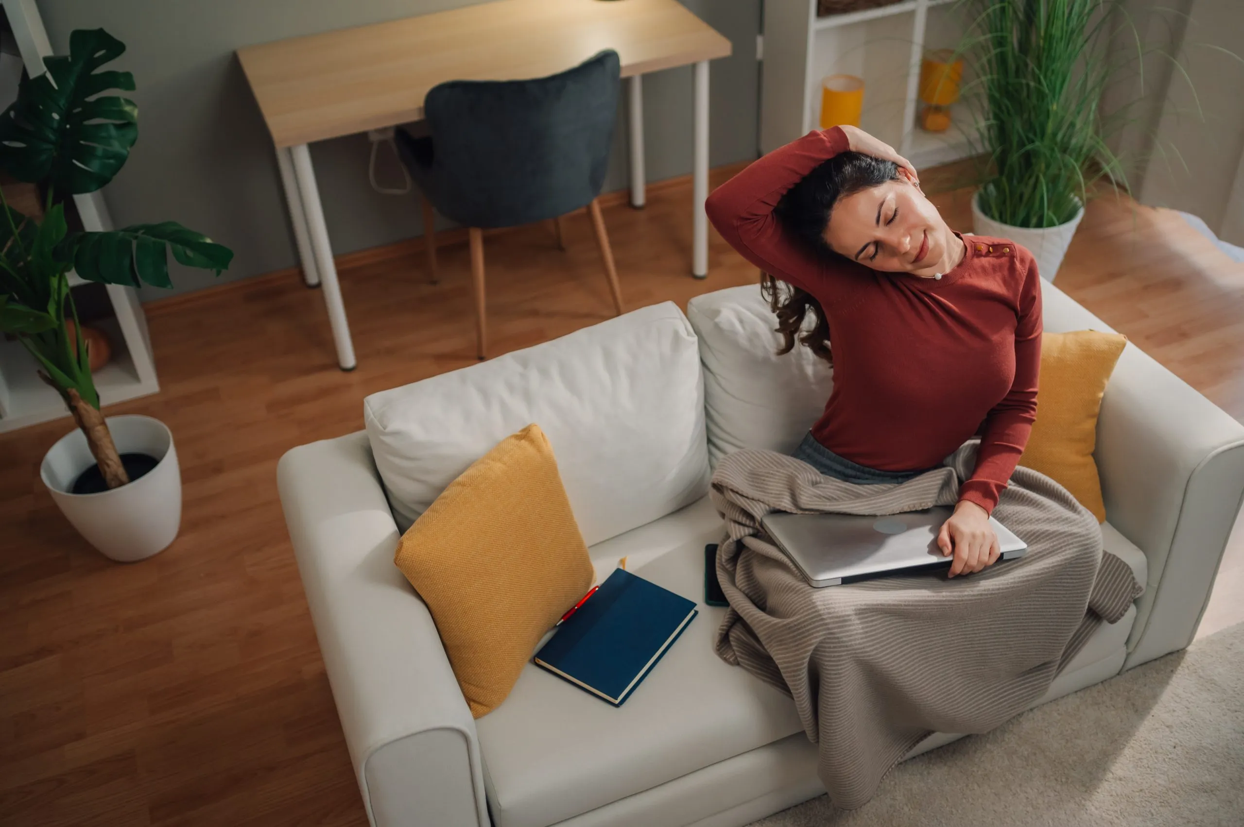 Hands arranging dried stems in a clear vase